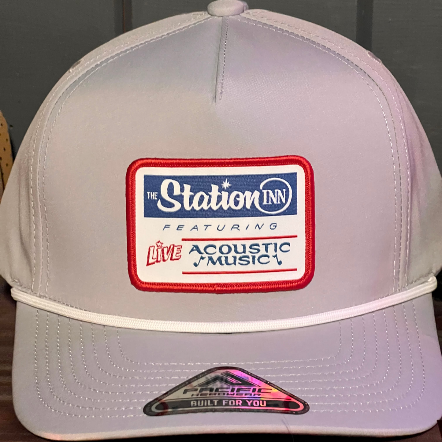 Gray cap with a logo featuring 'The Station Inn' on a wooden surface.